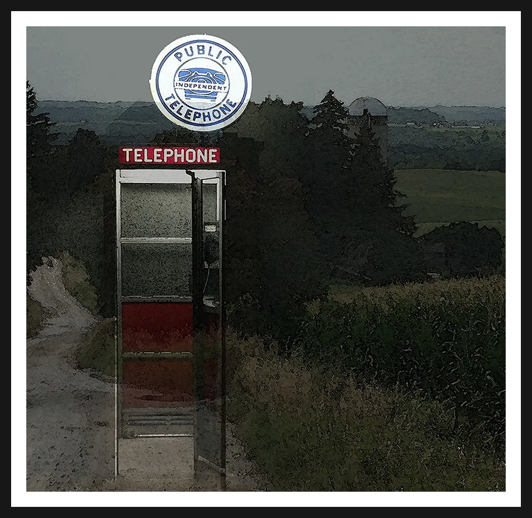 Red telephone booth in rural landscape