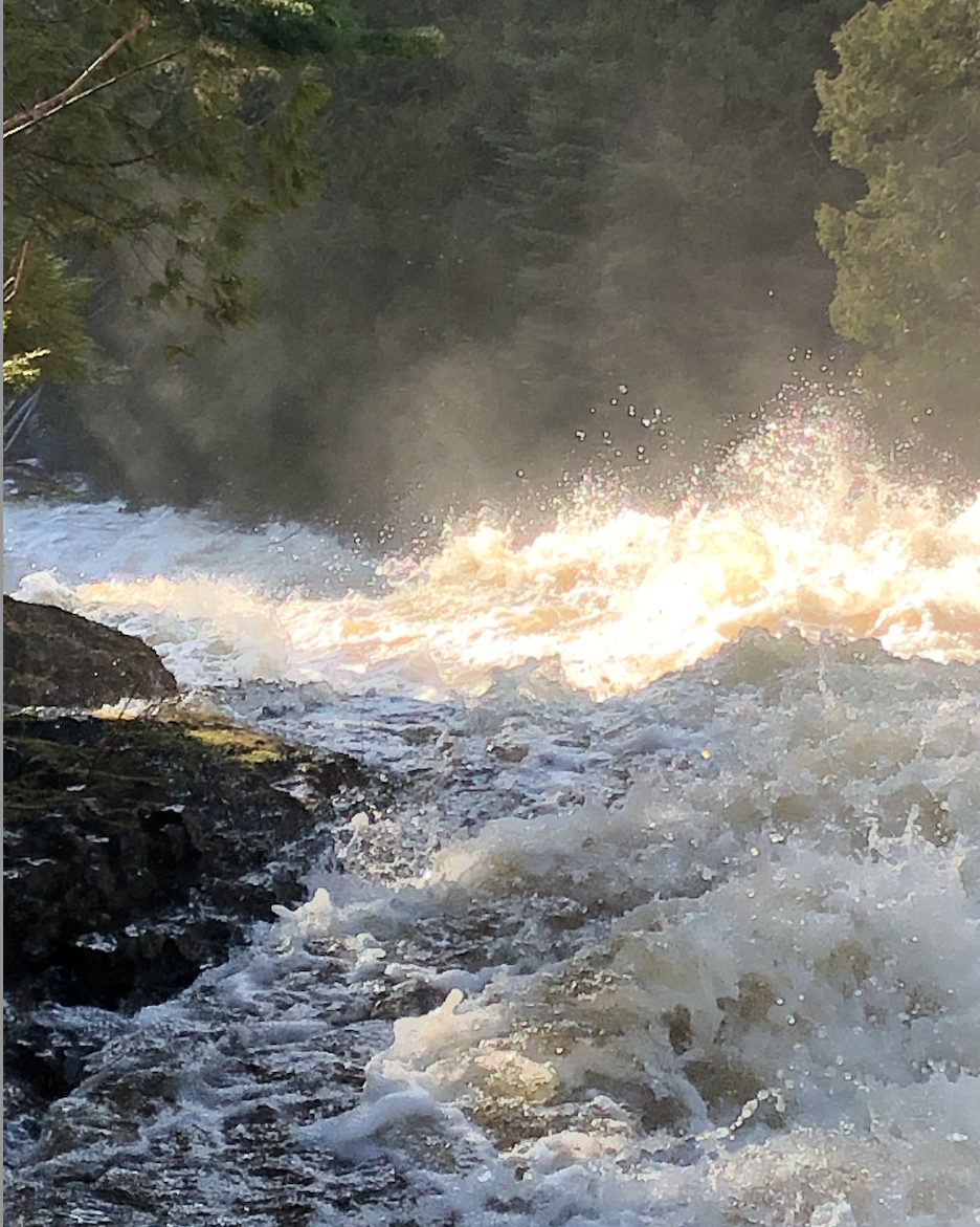 Rushing waterfall with sunlight reflections