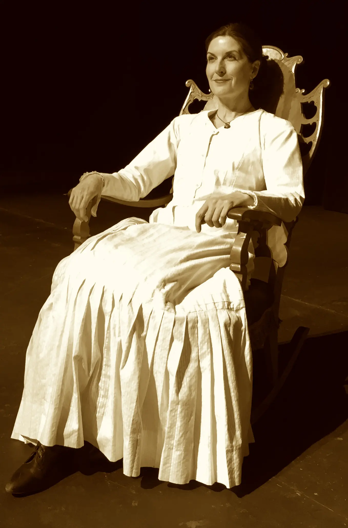 Woman in vintage dress sitting on chair.