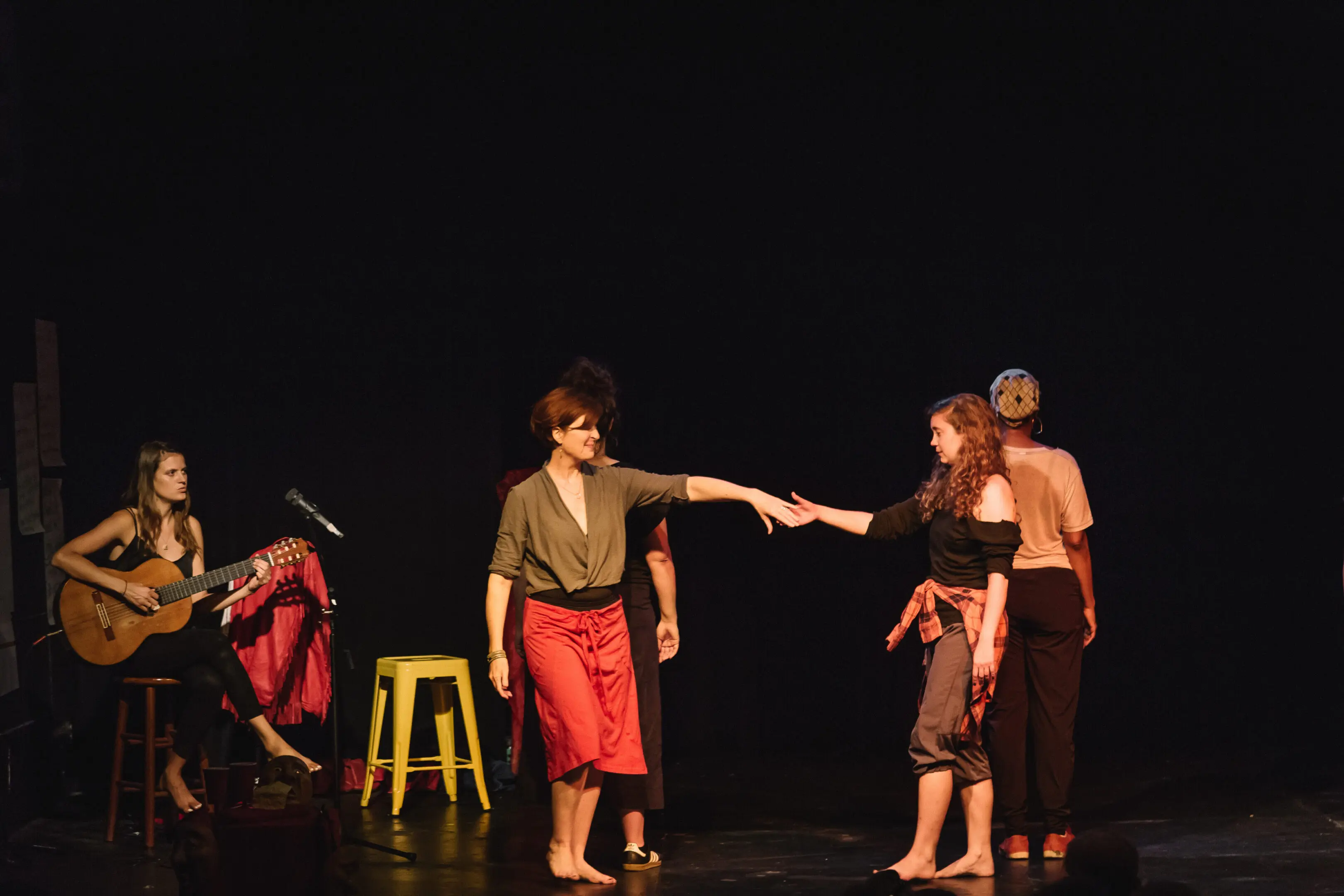 Performers on stage with guitar accompaniment.
