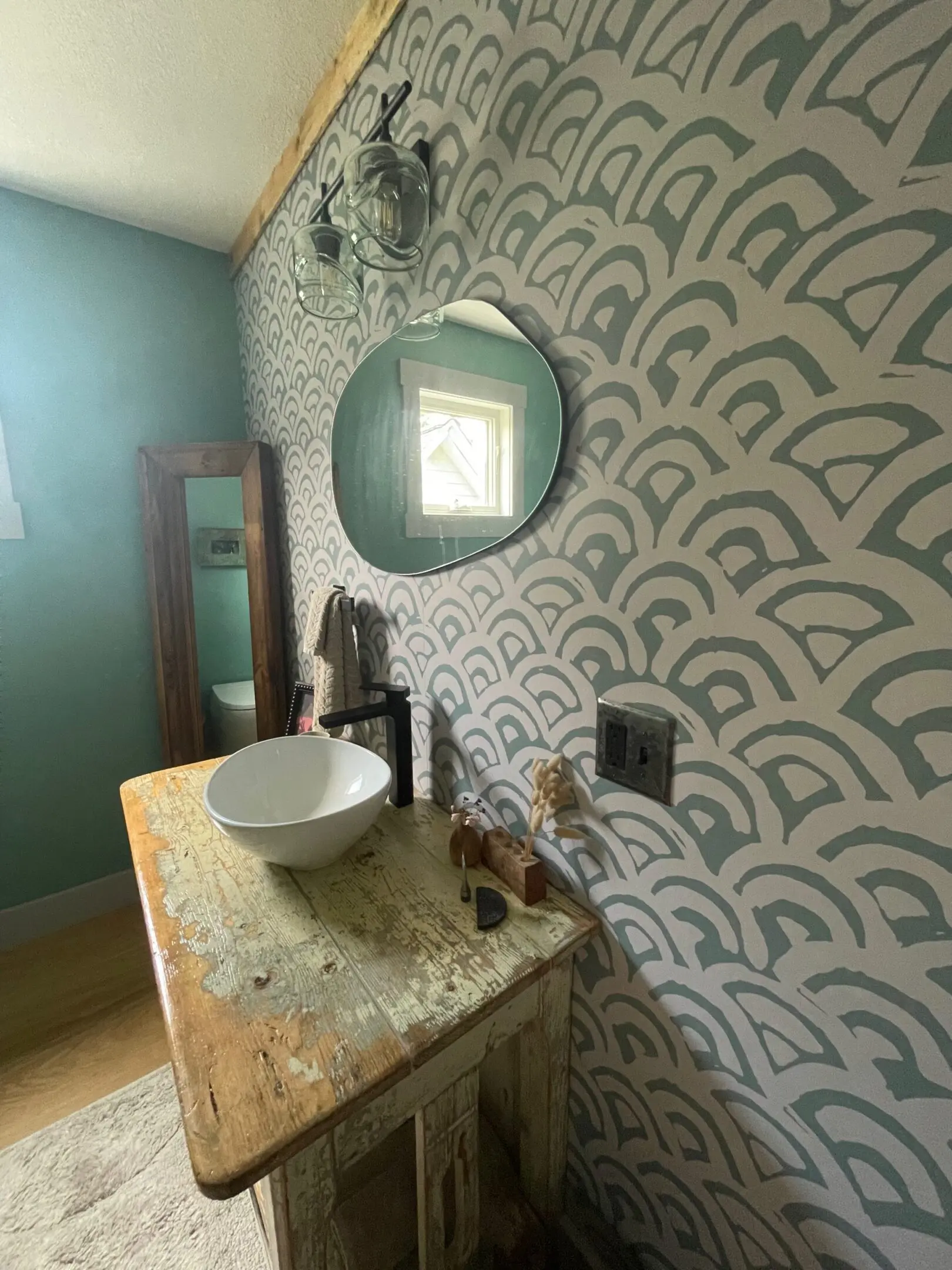 Vintage bathroom with patterned wall and sink.