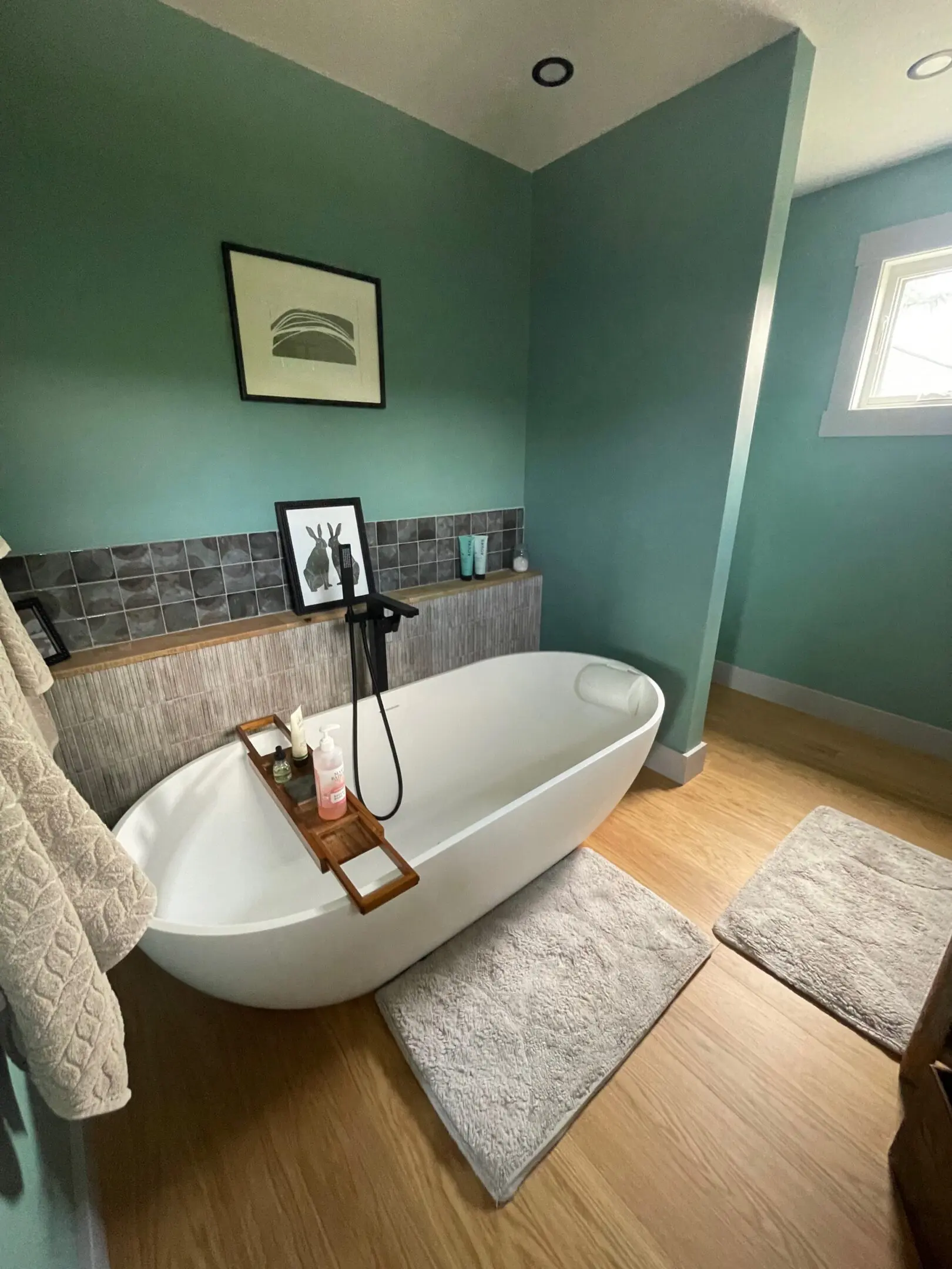 Modern bathroom with freestanding bathtub and decor.