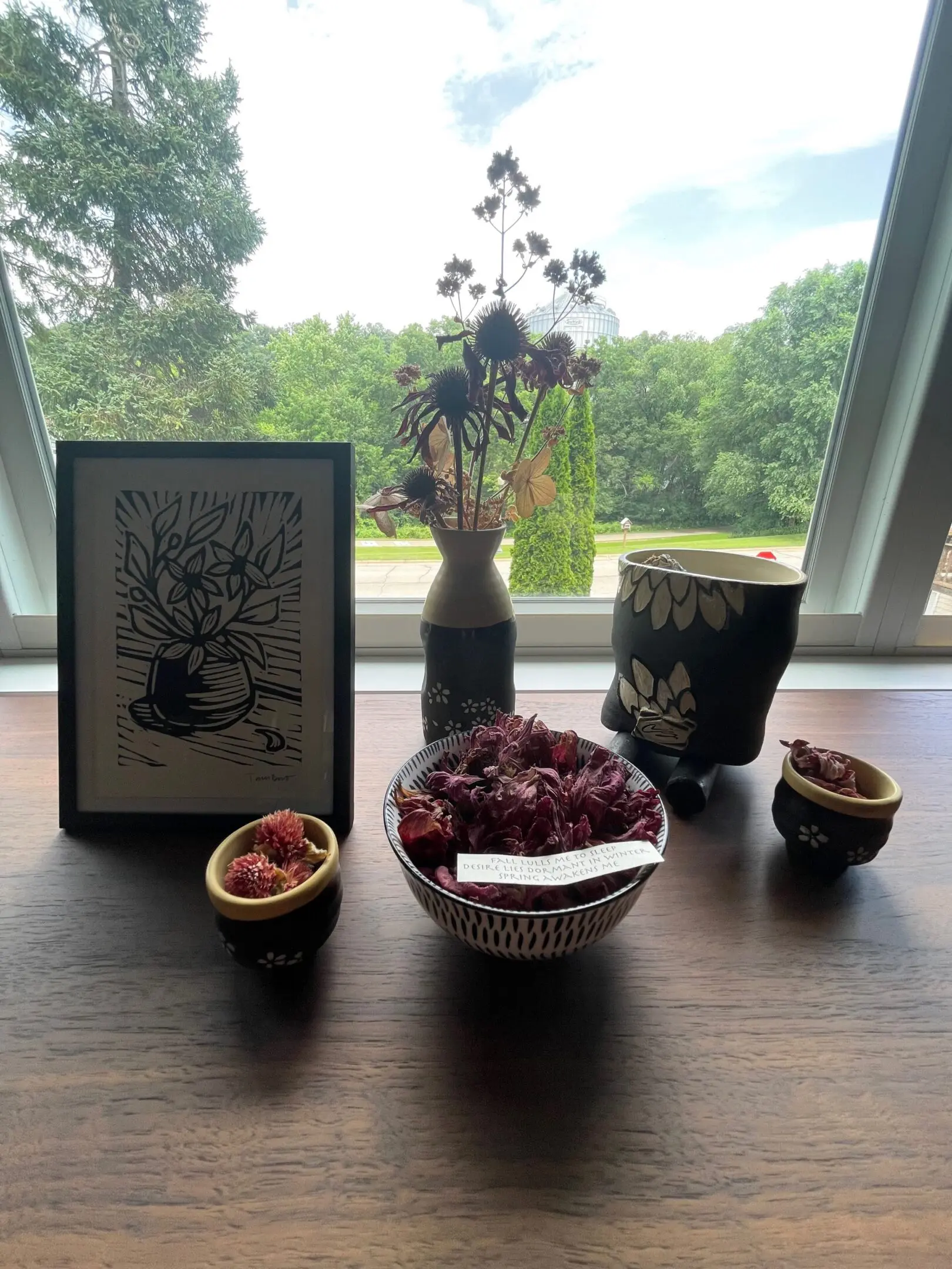 Decorative table with flowers and framed artwork.