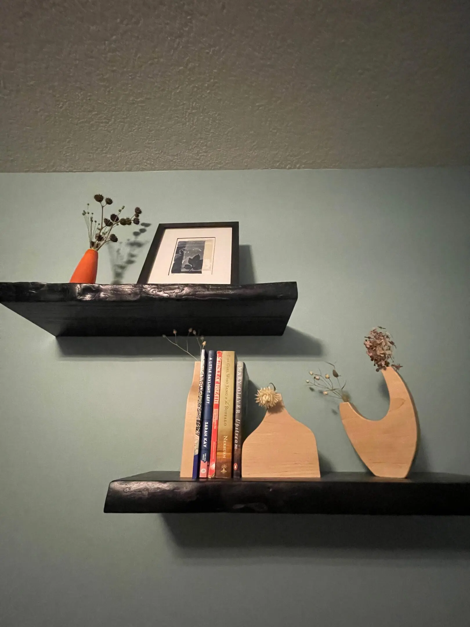 Two decorative shelves with books and art.