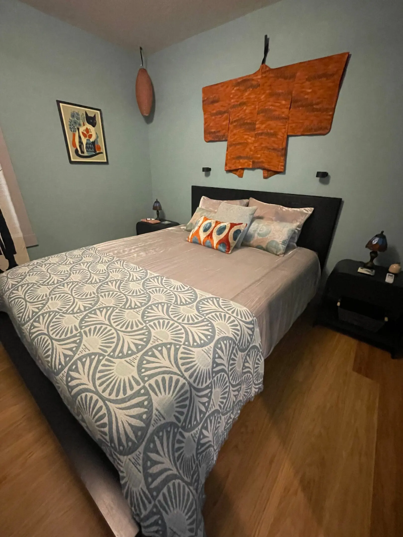 Bedroom with decorative kimono and patterned bedding.
