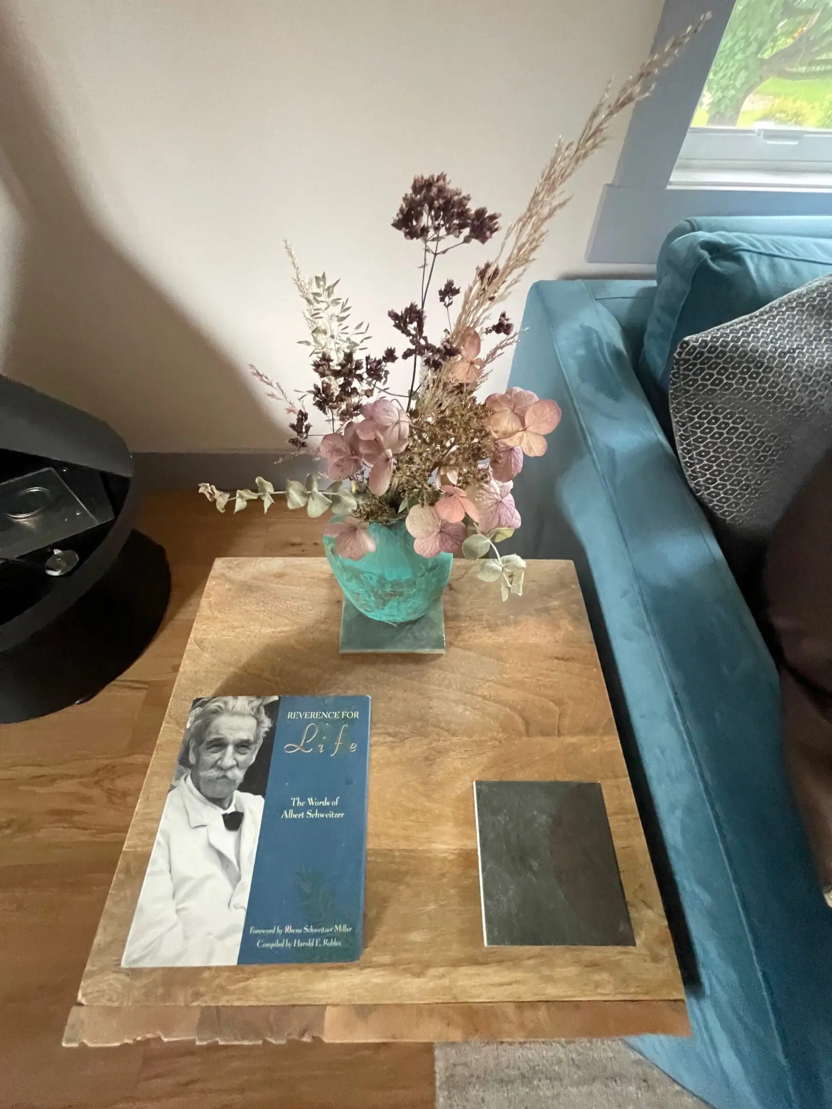 Table with book, vase, and flowers.