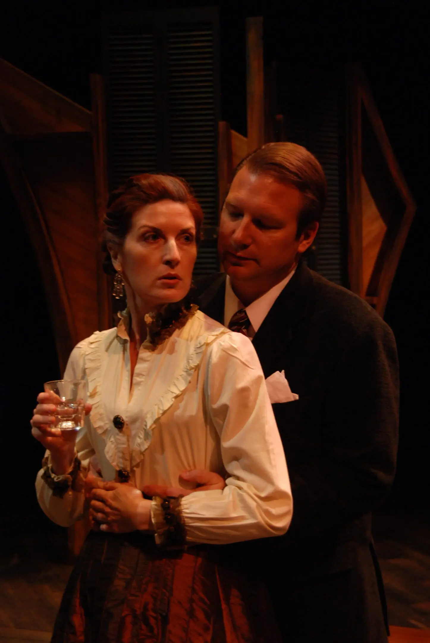 Two actors in a dramatic stage scene.