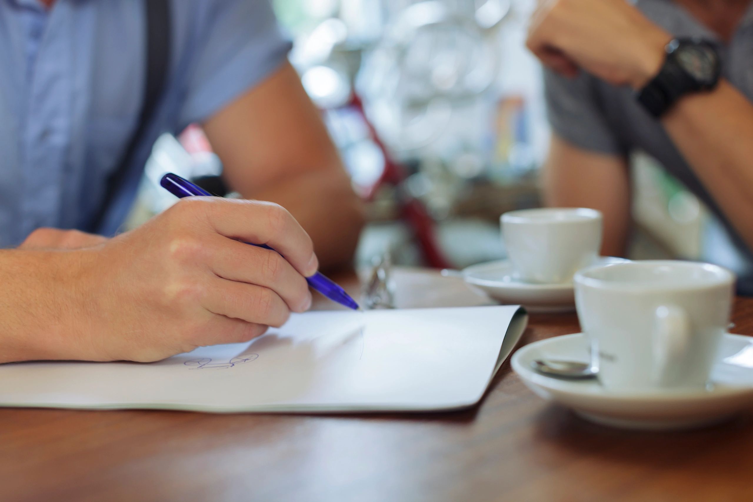 Person writing notes during a focused conversation