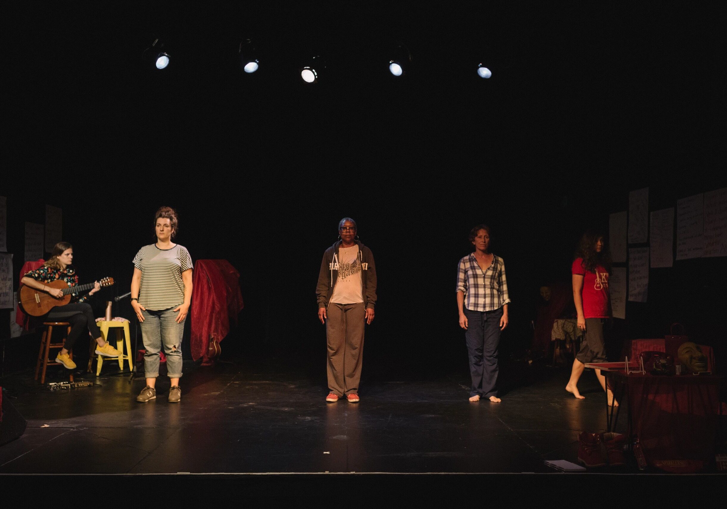 Group performing on a dimly lit stage.