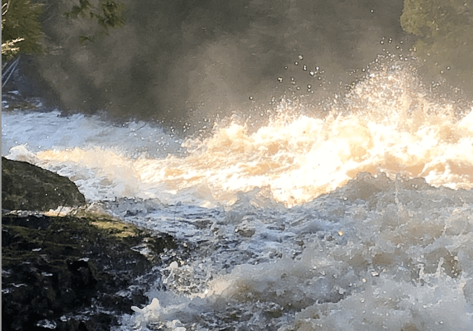 Rushing waterfall with sunlight reflections