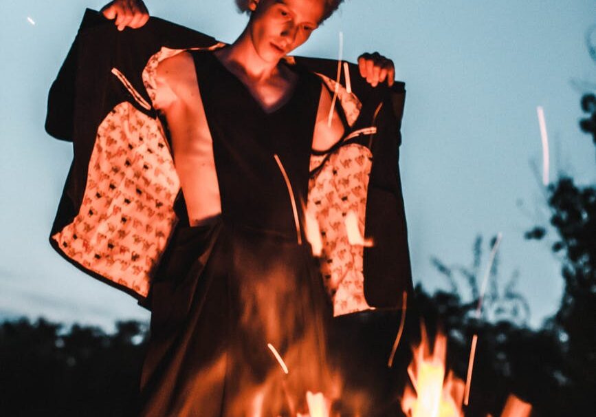 Person standing confidently by a fire