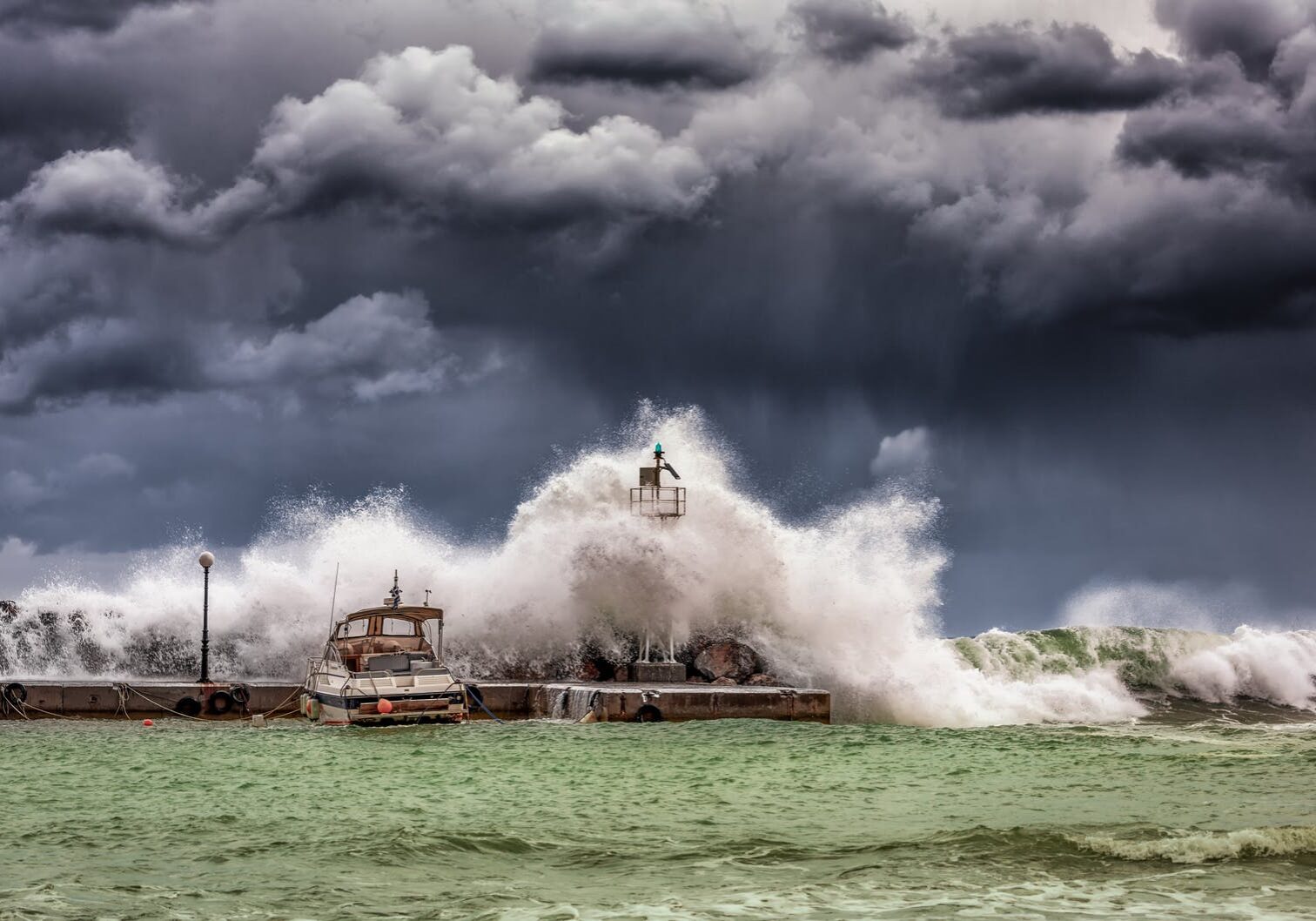 Stormy waves crashing against lighthouse pier